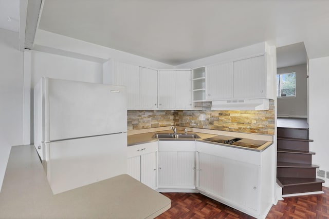 kitchen featuring backsplash, black electric stovetop, white cabinets, white refrigerator, and sink