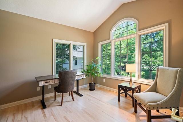 office area with light hardwood / wood-style floors and vaulted ceiling