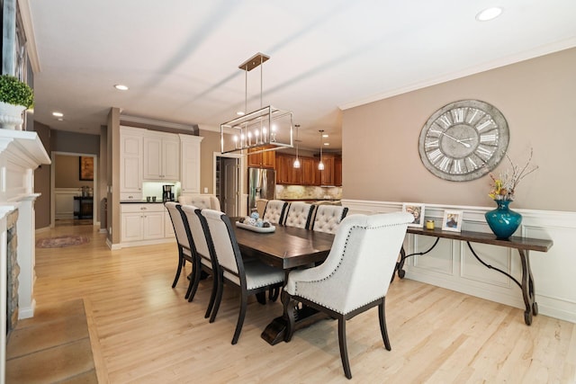 dining room with a chandelier, light hardwood / wood-style flooring, and ornamental molding