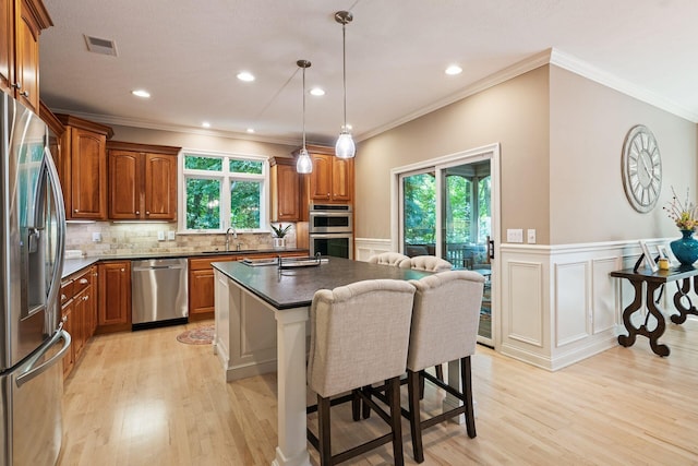 kitchen with a center island, light hardwood / wood-style floors, sink, and appliances with stainless steel finishes