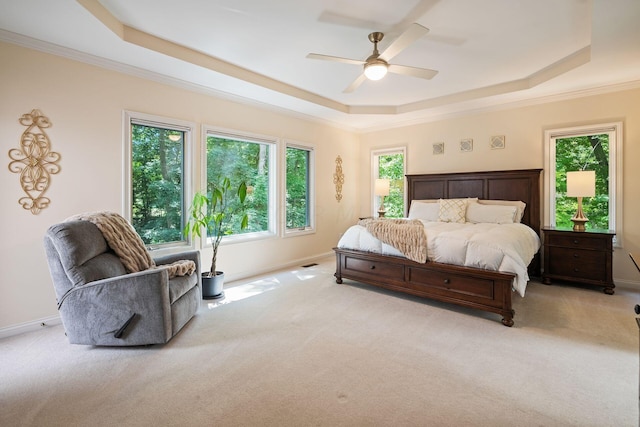 bedroom featuring a raised ceiling, ceiling fan, crown molding, and light carpet