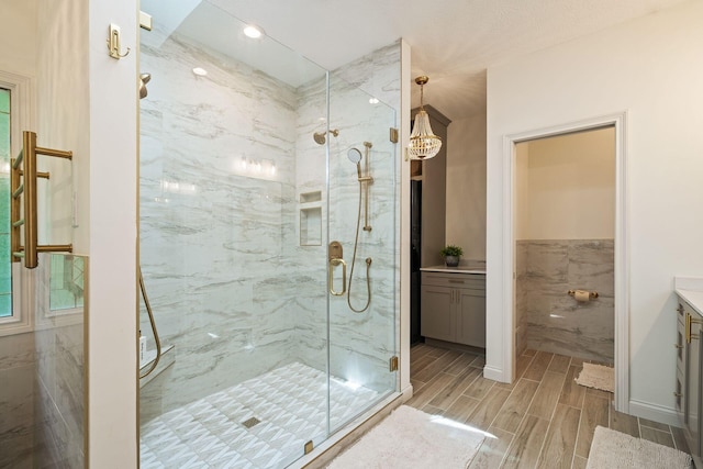 bathroom with vanity, an enclosed shower, and tile walls