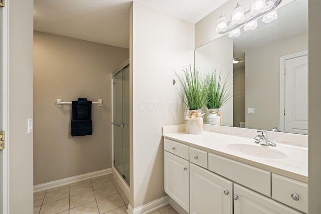 bathroom with a textured ceiling, tile patterned flooring, vanity, and an enclosed shower