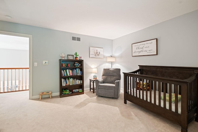 bedroom with light carpet and a nursery area