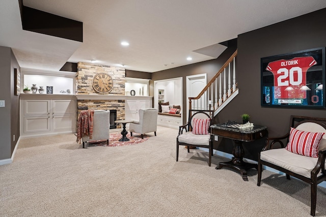 carpeted living room featuring a stone fireplace