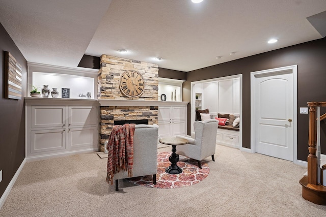 carpeted living room with a fireplace and a textured ceiling