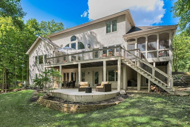 rear view of property featuring a yard, an outdoor living space, a patio area, and a wooden deck