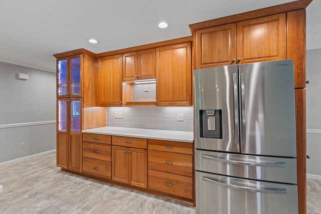 kitchen with stainless steel fridge with ice dispenser, ornamental molding, and tasteful backsplash