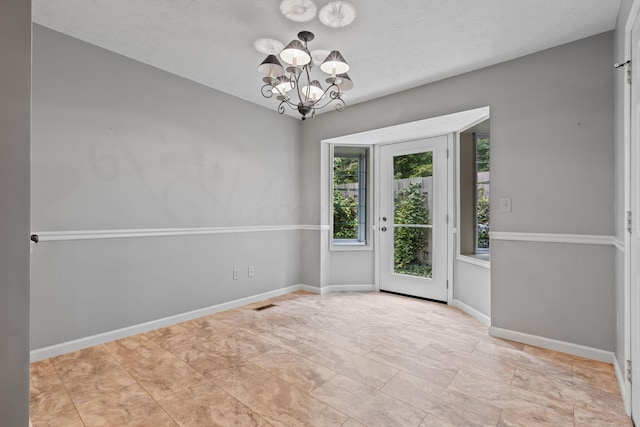 interior space featuring a chandelier and a textured ceiling