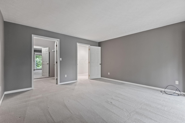 unfurnished bedroom with a textured ceiling and light carpet