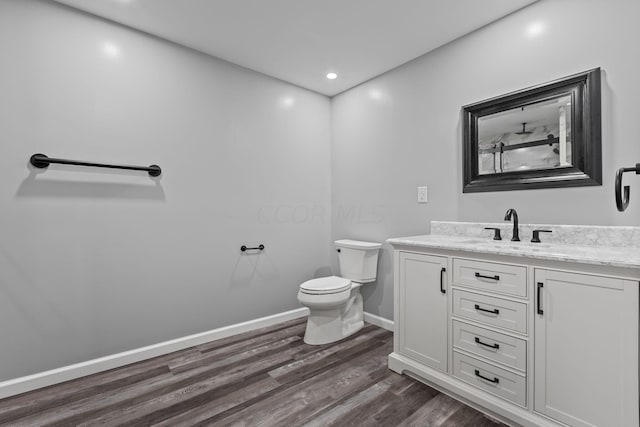 bathroom with vanity, toilet, and wood-type flooring