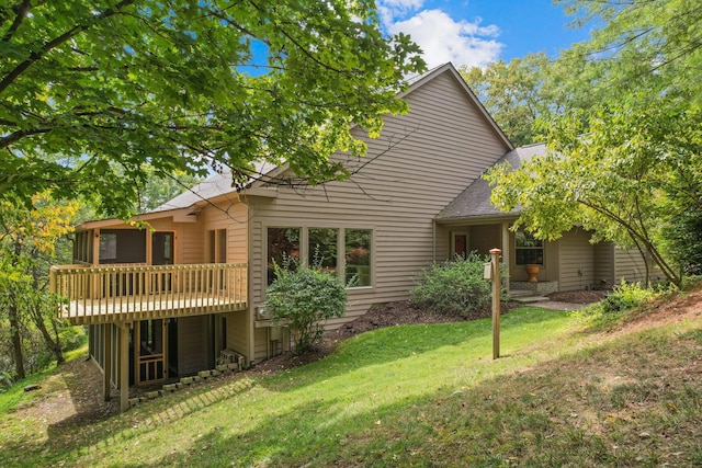 rear view of property with a yard and a wooden deck