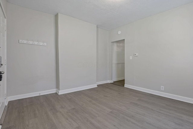 unfurnished room with wood-type flooring and a textured ceiling