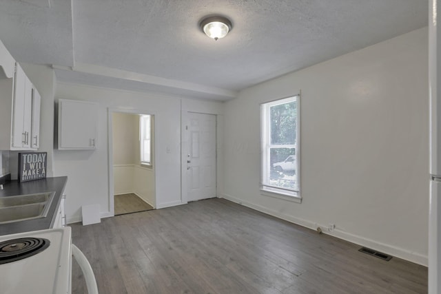 kitchen featuring stove, white cabinets, sink, a textured ceiling, and light hardwood / wood-style floors