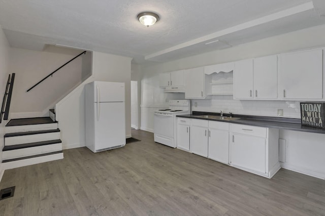 kitchen with white appliances, sink, tasteful backsplash, light hardwood / wood-style floors, and white cabinetry