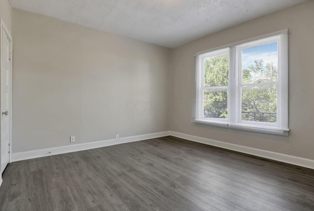 empty room featuring dark hardwood / wood-style flooring and a textured ceiling