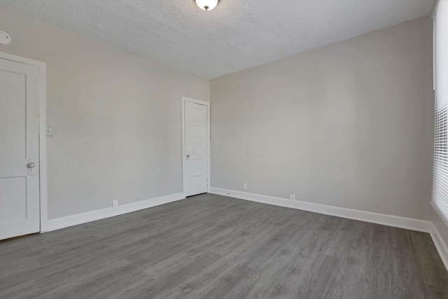 empty room featuring dark hardwood / wood-style flooring and a textured ceiling