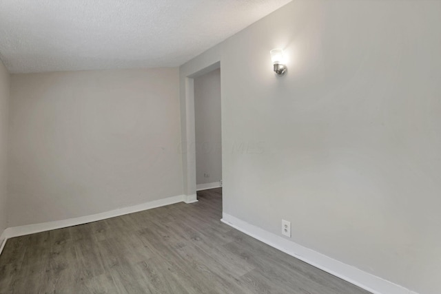 unfurnished room featuring hardwood / wood-style flooring and a textured ceiling