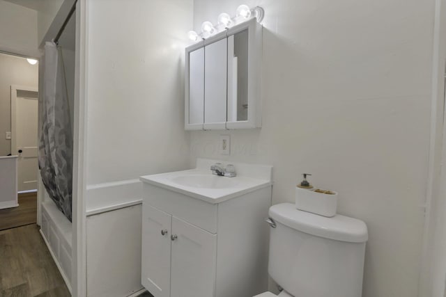 full bathroom with hardwood / wood-style floors, vanity, shower / bath combination with curtain, and toilet