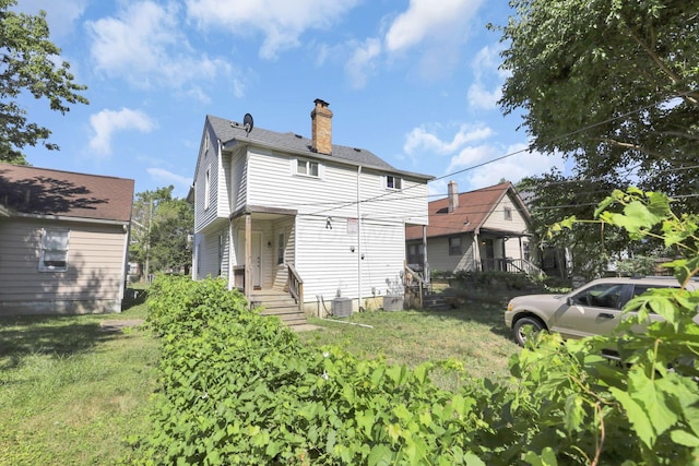 back of house with a lawn and central AC unit