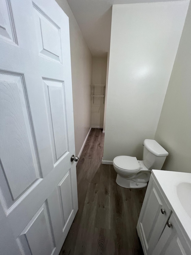 bathroom with hardwood / wood-style floors, vanity, and toilet