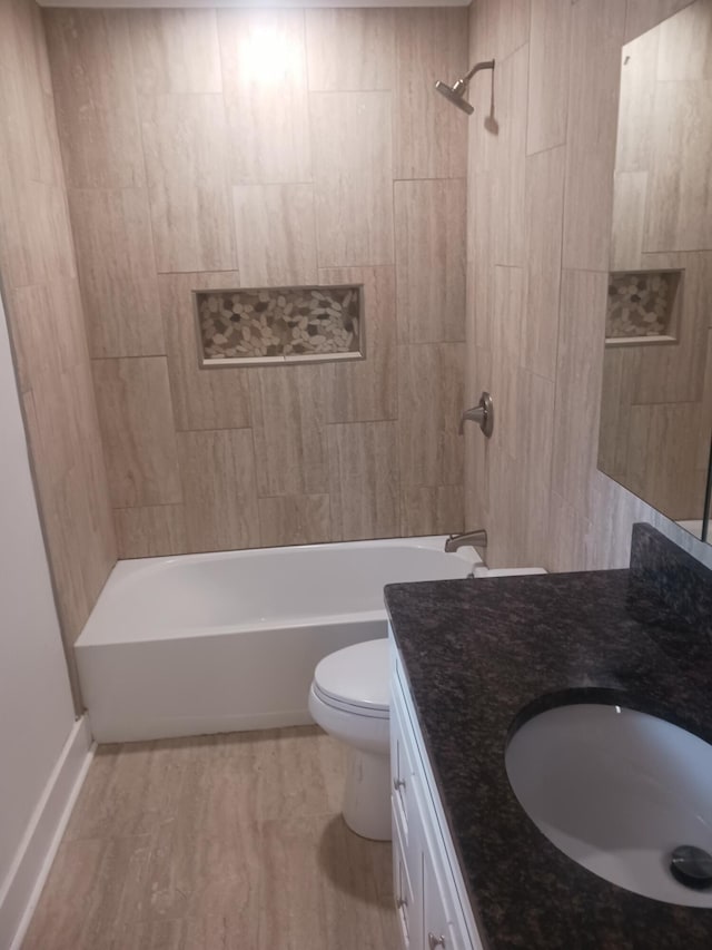 full bathroom with vanity, tiled shower / bath combo, and toilet