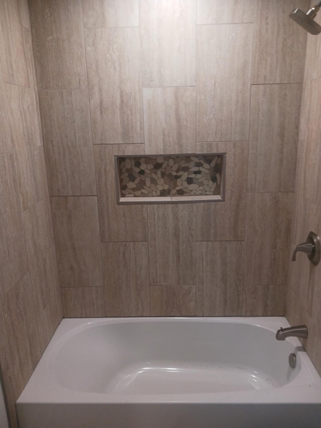 bathroom featuring tiled shower / bath