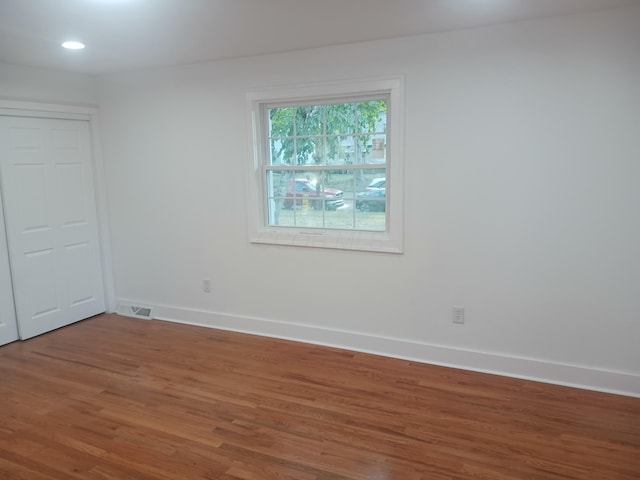 empty room with hardwood / wood-style flooring