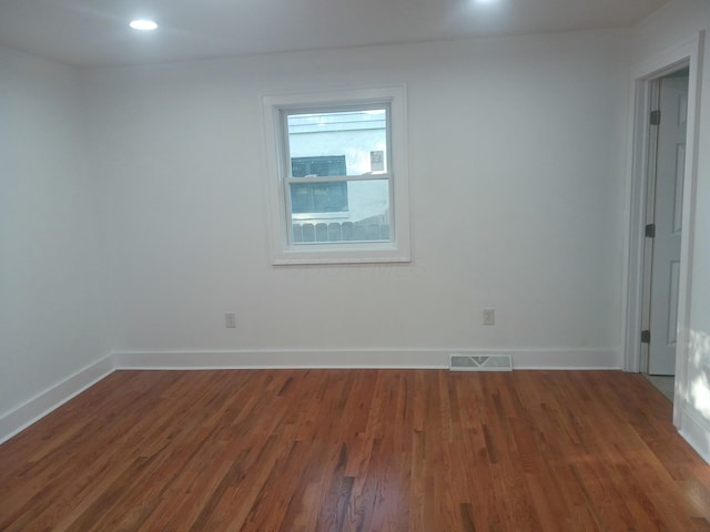 unfurnished room with dark wood-type flooring