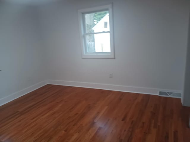 unfurnished room with dark hardwood / wood-style floors