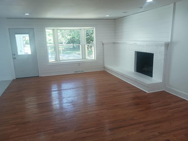 unfurnished living room with dark hardwood / wood-style flooring and a fireplace