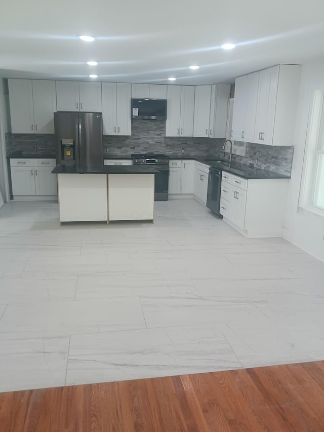 kitchen featuring sink, tasteful backsplash, light hardwood / wood-style flooring, and black appliances