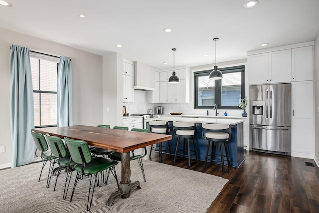 dining space with dark hardwood / wood-style flooring and sink