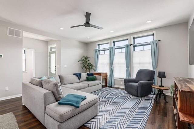 living room featuring ceiling fan and dark wood-type flooring