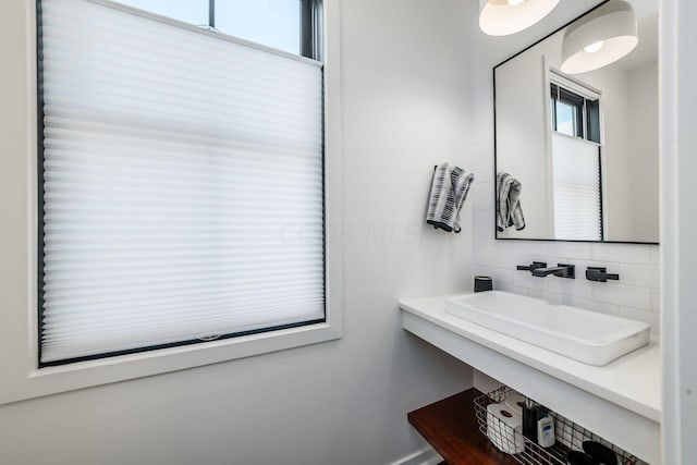 bathroom with tasteful backsplash, plenty of natural light, and sink