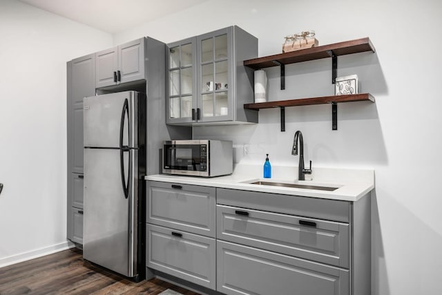 kitchen with gray cabinets, sink, stainless steel appliances, and dark wood-type flooring