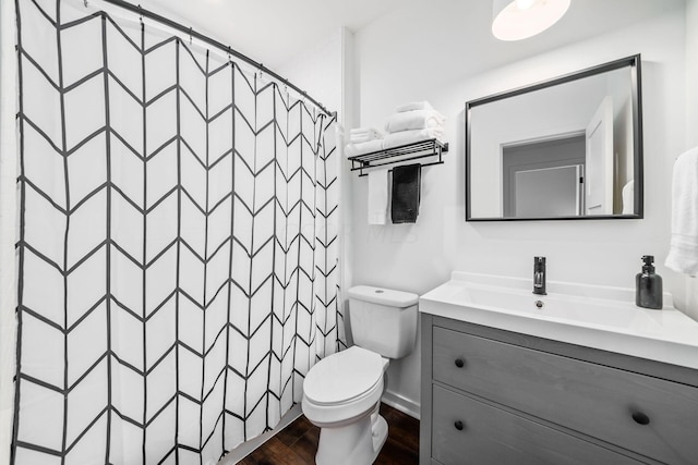 bathroom featuring vanity, hardwood / wood-style flooring, toilet, and curtained shower