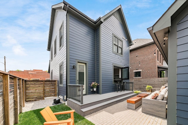 back of property featuring a patio area and a deck