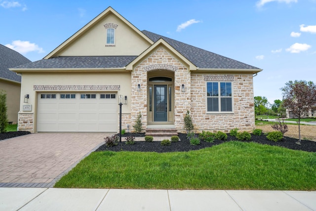 6178 Garden Loop, Westerville, OH 43082 - view of front facade featuring stone siding, an attached garage, stucco siding, a front lawn, and decorative driveway