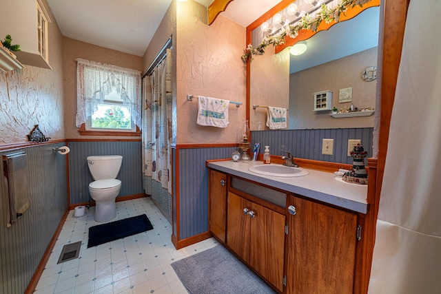 bathroom featuring vanity, toilet, and curtained shower