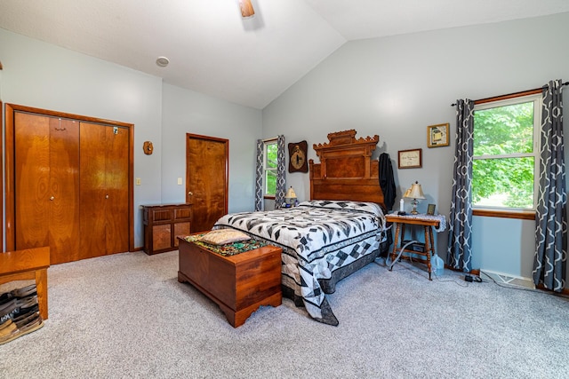 bedroom featuring ceiling fan, a closet, light colored carpet, and vaulted ceiling