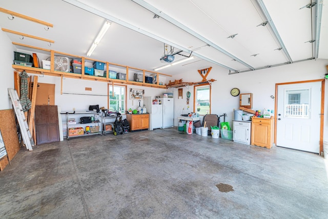 garage with white fridge and a garage door opener