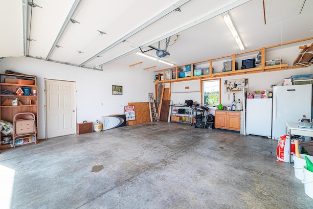 garage featuring white refrigerator and a garage door opener