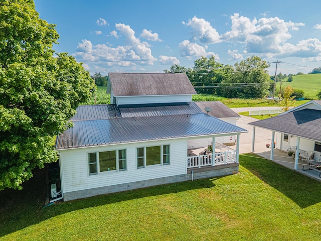 rear view of house with a lawn and covered porch