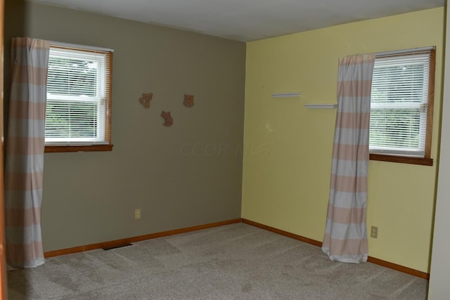 carpeted spare room featuring a wealth of natural light