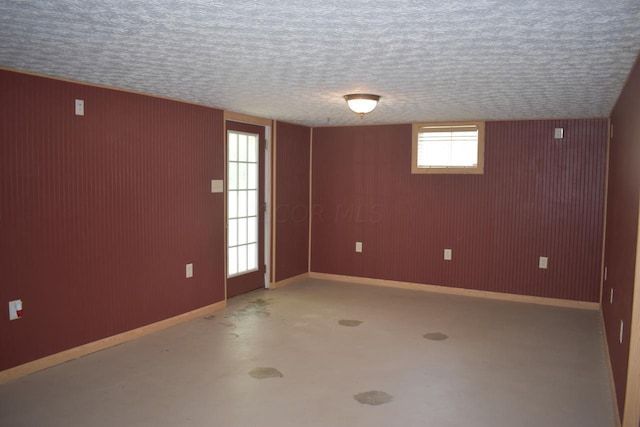 empty room featuring a textured ceiling and concrete floors