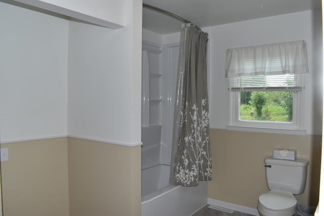 bathroom featuring shower / bath combination with curtain and toilet