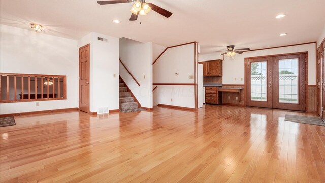 unfurnished living room with ceiling fan, french doors, and light hardwood / wood-style flooring