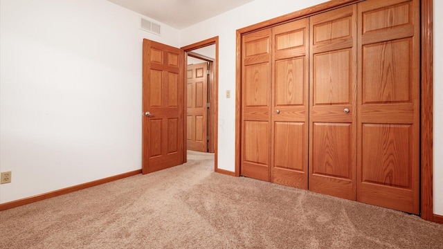 unfurnished bedroom with light carpet and a closet