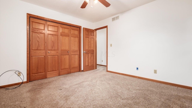 unfurnished bedroom featuring ceiling fan, a closet, and light carpet